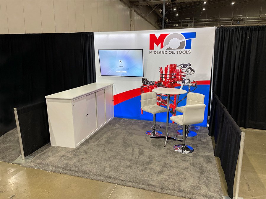 Midland Oil Tools inline booth with a printed backwall and bar seating