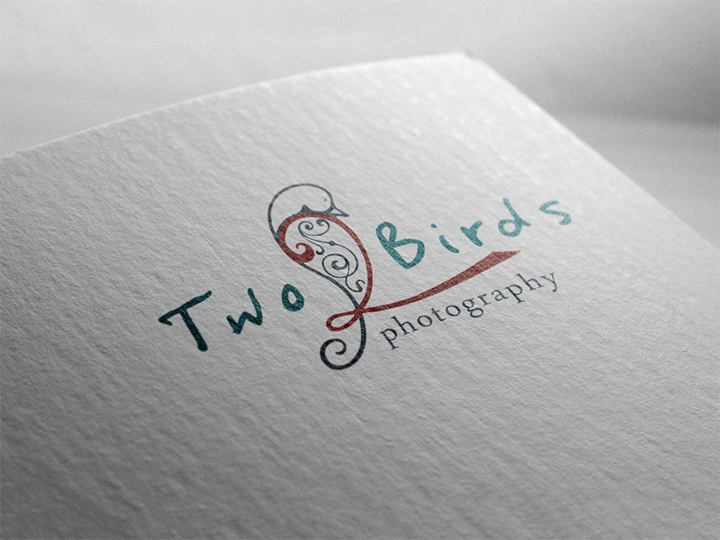 Two Birds Photography logo with a filigree bird, printed on textured paper